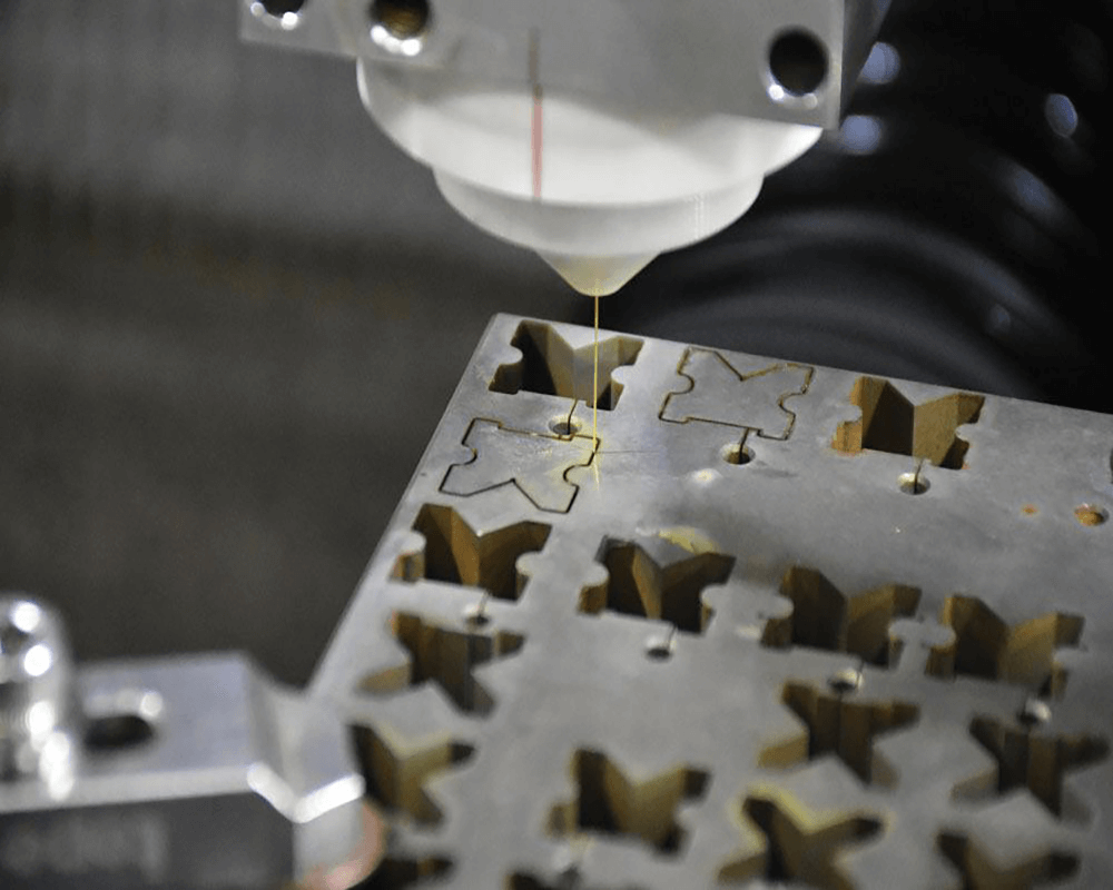 Wire guide positioned over a metal workpiece for precision wire cutting
